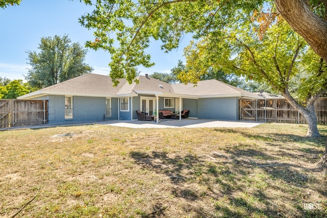 ranch-style house with an outdoor living space, a patio area, and a front yard