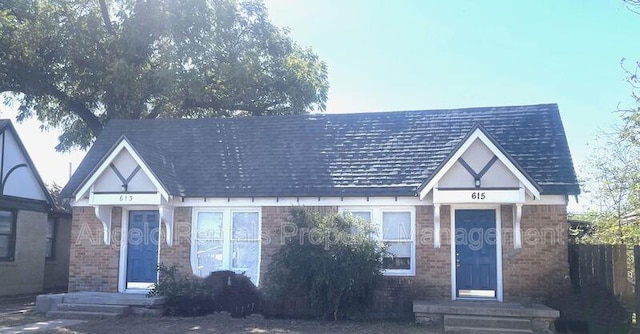 tudor house featuring brick siding