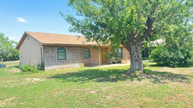 7490 Canna St, San Angelo, TX 76901 - view of front of home with brick siding, fence, a patio, and a front lawn