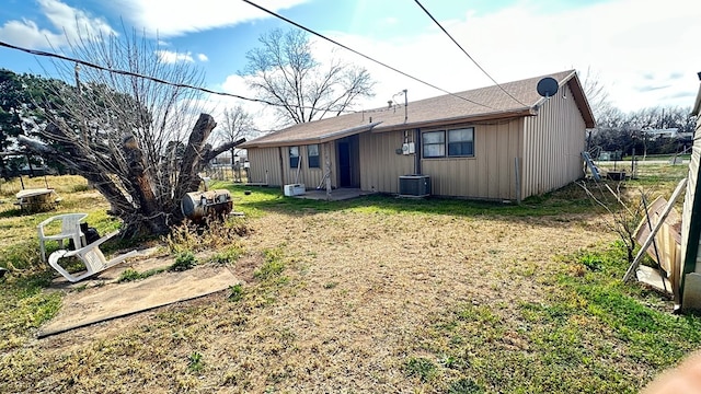 back of house featuring a lawn, central AC unit, and fence