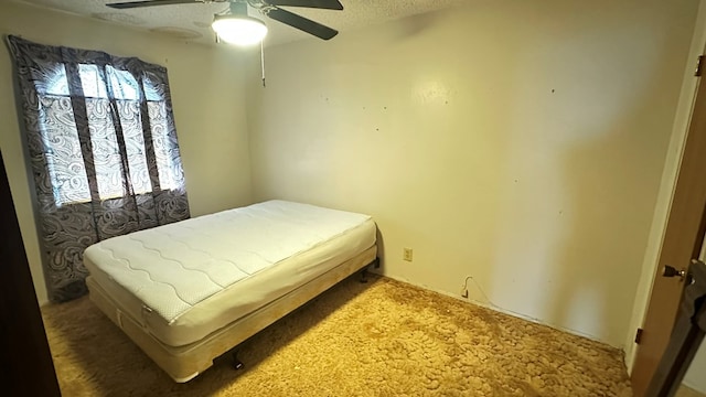 bedroom with a ceiling fan and a textured ceiling