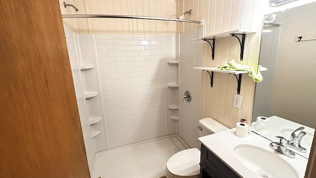 bathroom featuring a stall shower, toilet, and vanity