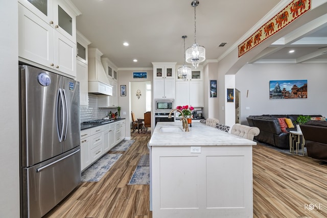 4710 Shadow Crk, San Angelo, TX 76904 - kitchen with stainless steel appliances, premium range hood, a sink, open floor plan, and crown molding
