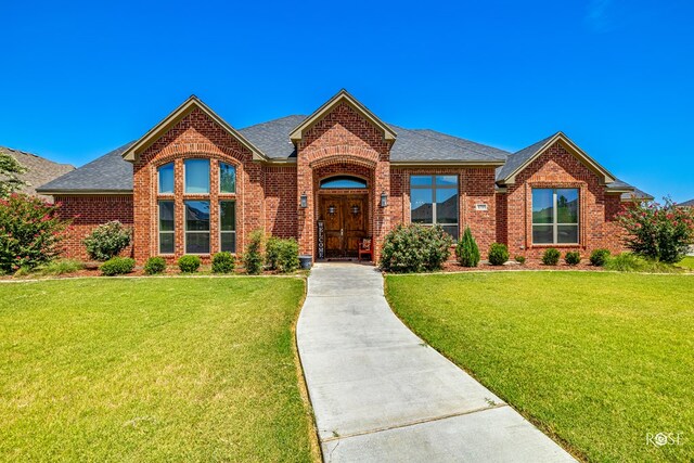 4710 Shadow Crk, San Angelo, TX 76904 - view of front facade featuring brick siding, roof with shingles, and a front yard