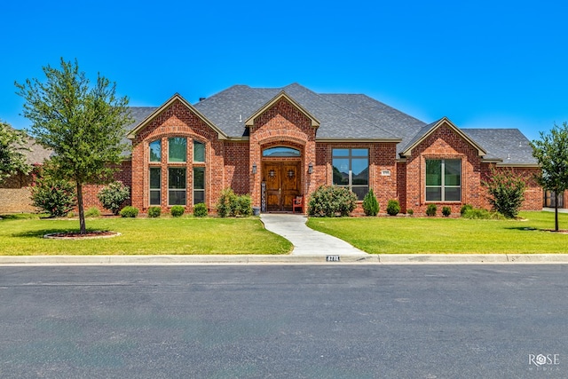 4710 Shadow Crk, San Angelo, TX 76904 - view of front of house with brick siding, a front yard, and a shingled roof
