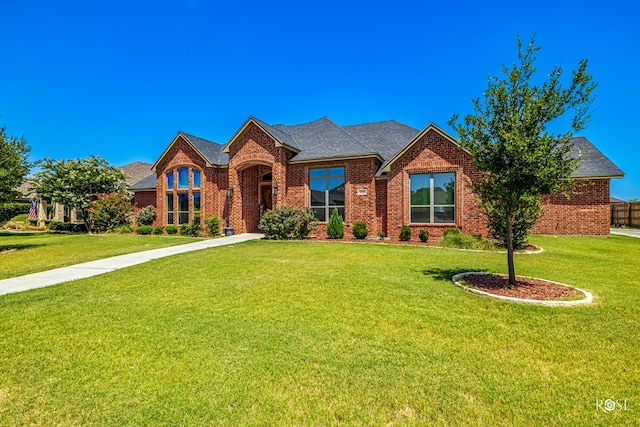 4710 Shadow Crk, San Angelo, TX 76904 - view of front facade featuring brick siding, a front lawn, and roof with shingles