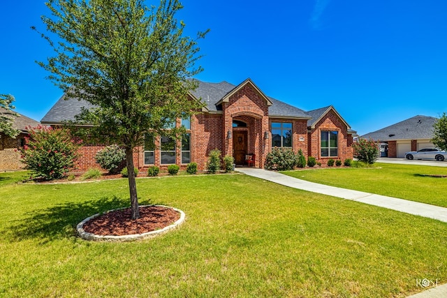 4710 Shadow Crk, San Angelo, TX 76904 - view of front of home with brick siding, a front yard, and a shingled roof