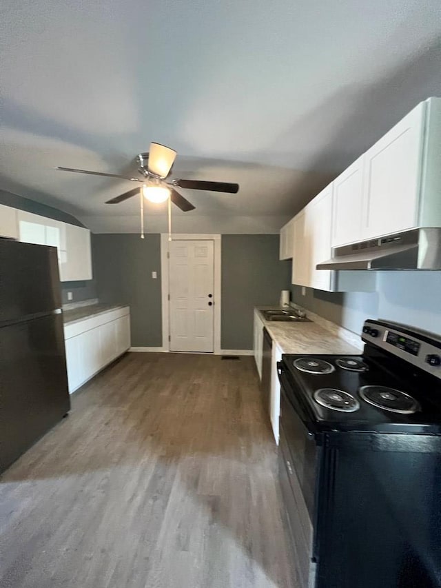 kitchen featuring wood finished floors, a ceiling fan, electric range, freestanding refrigerator, and white cabinetry