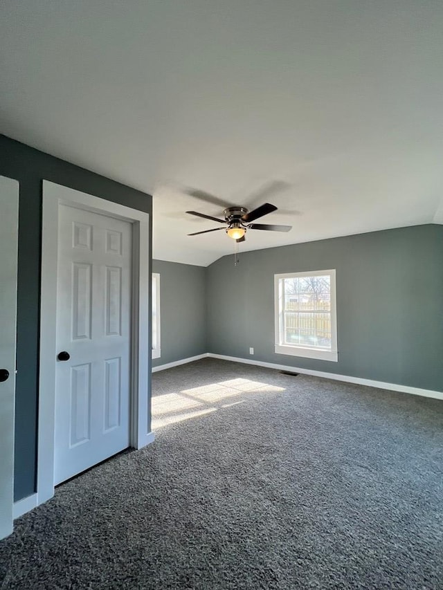 interior space featuring vaulted ceiling, baseboards, and ceiling fan