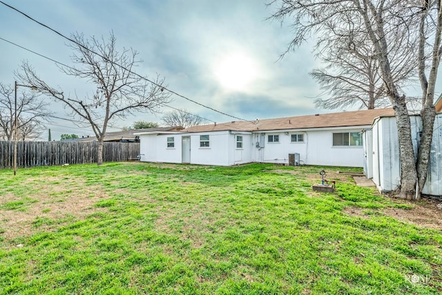 rear view of house featuring a yard and central AC