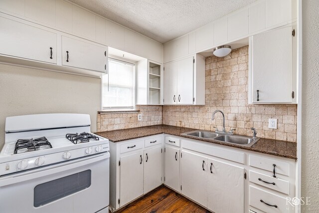 2126 La Cruz St, San Angelo, TX 76903 - kitchen with white gas stove, a sink, a textured ceiling, backsplash, and dark countertops