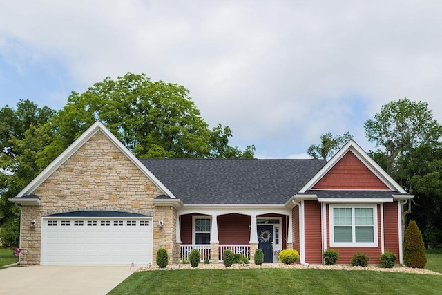 craftsman inspired home with a front lawn, covered porch, and a garage