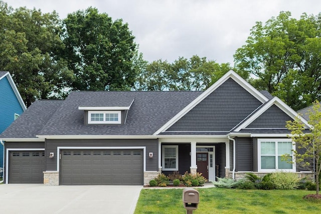 craftsman inspired home featuring a garage and a front yard