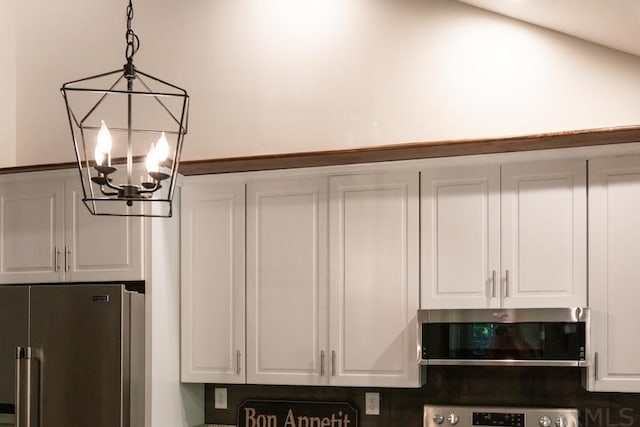 interior details featuring appliances with stainless steel finishes and an inviting chandelier