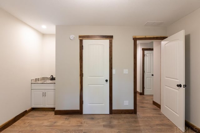 unfurnished bedroom featuring sink and wood-type flooring