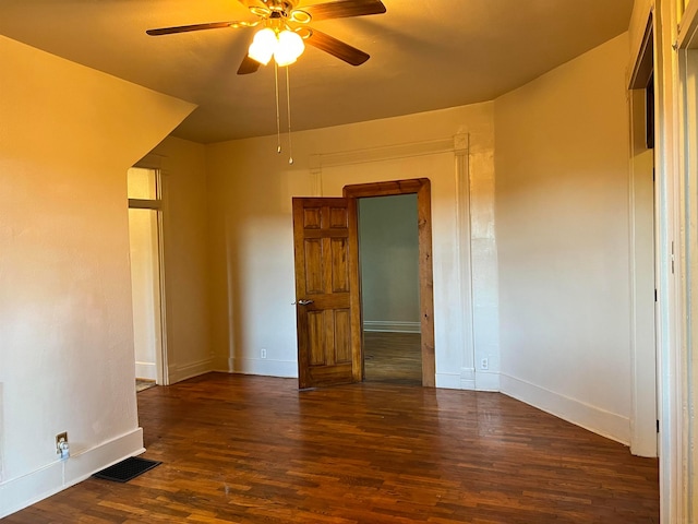 empty room with ceiling fan and dark hardwood / wood-style floors