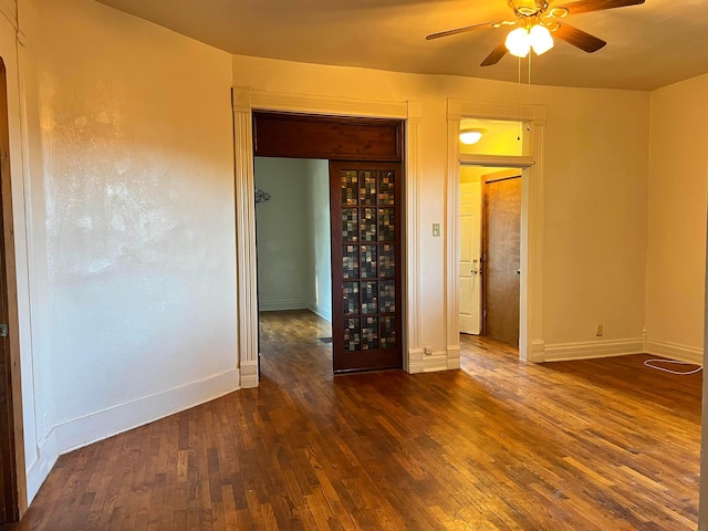 unfurnished room featuring ceiling fan and dark wood-type flooring