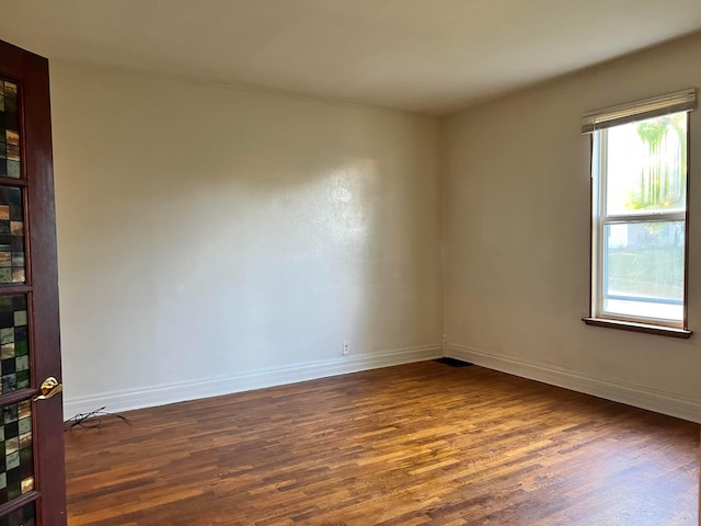 unfurnished room with a healthy amount of sunlight and dark hardwood / wood-style flooring