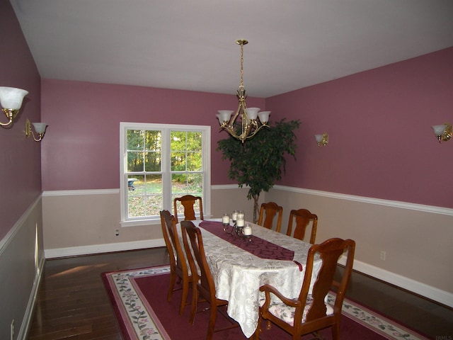 dining space with an inviting chandelier and dark hardwood / wood-style flooring