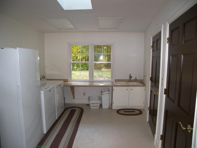 interior space featuring washing machine and clothes dryer, tile floors, and sink