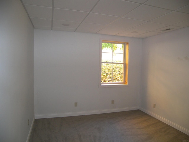 carpeted empty room with a drop ceiling