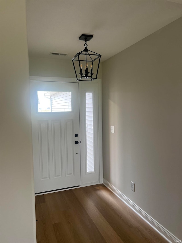 entrance foyer with hardwood / wood-style floors and an inviting chandelier