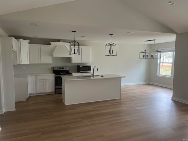 kitchen with white cabinetry, vaulted ceiling, appliances with stainless steel finishes, a center island with sink, and light hardwood / wood-style floors