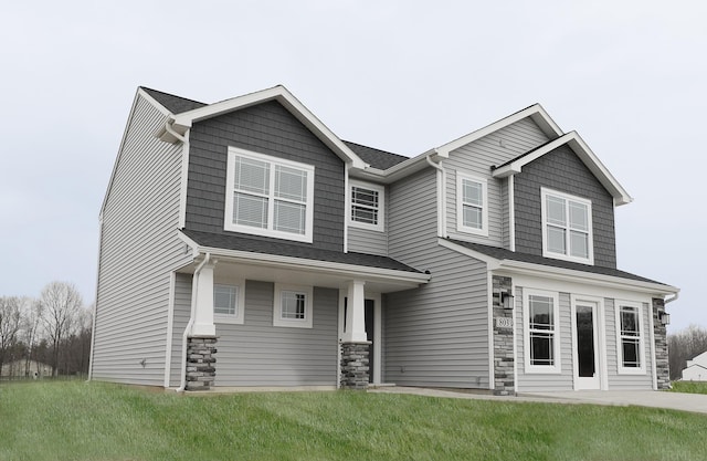 craftsman inspired home featuring a front yard and stone siding