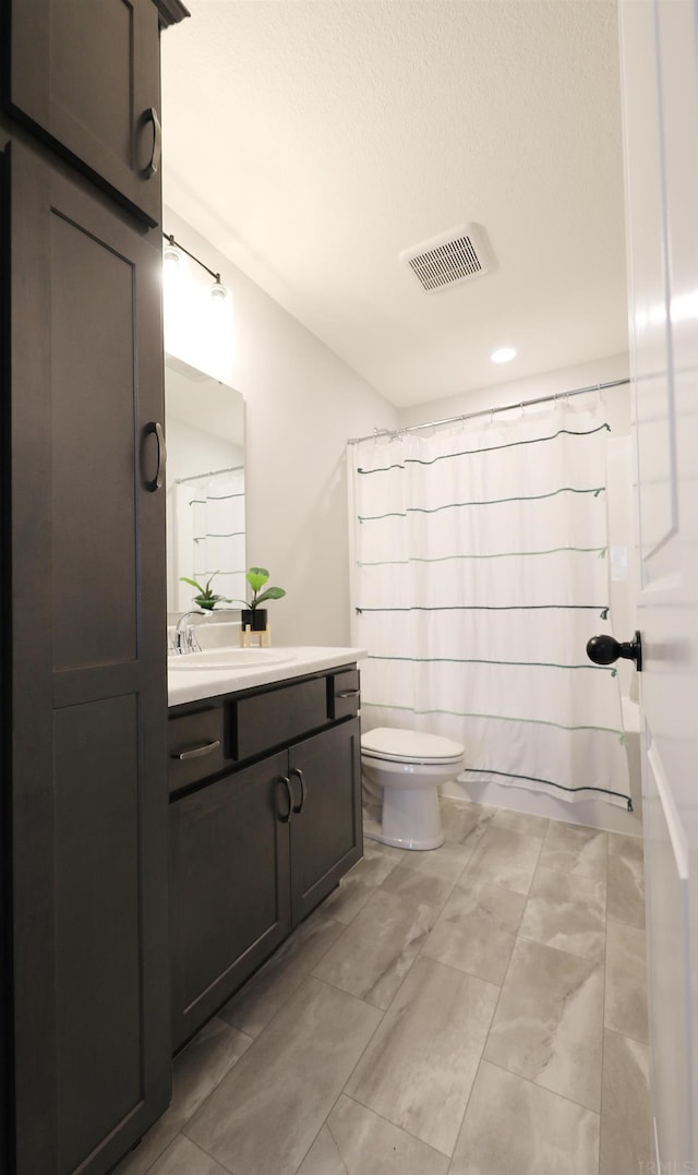 full bathroom featuring visible vents, vanity, and toilet