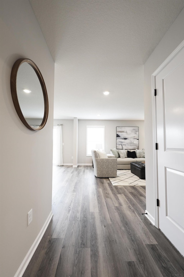 hallway with baseboards, wood finished floors, and recessed lighting