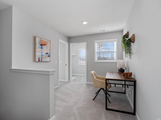 office space with light carpet, visible vents, and baseboards