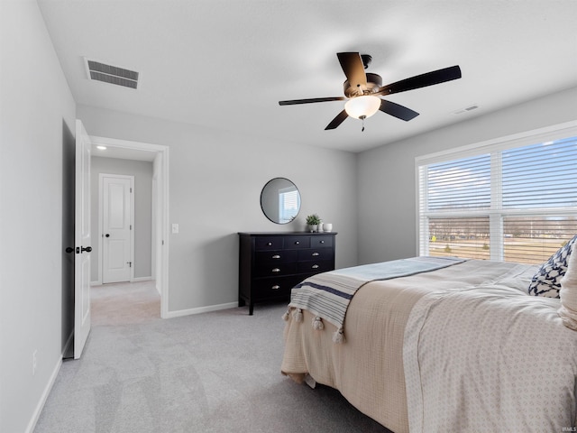 bedroom featuring light carpet, a ceiling fan, visible vents, and baseboards