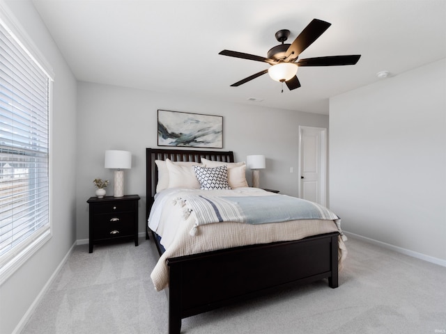 bedroom featuring baseboards, ceiling fan, visible vents, and light colored carpet