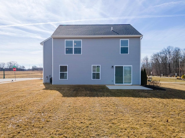 back of house with a lawn and a patio