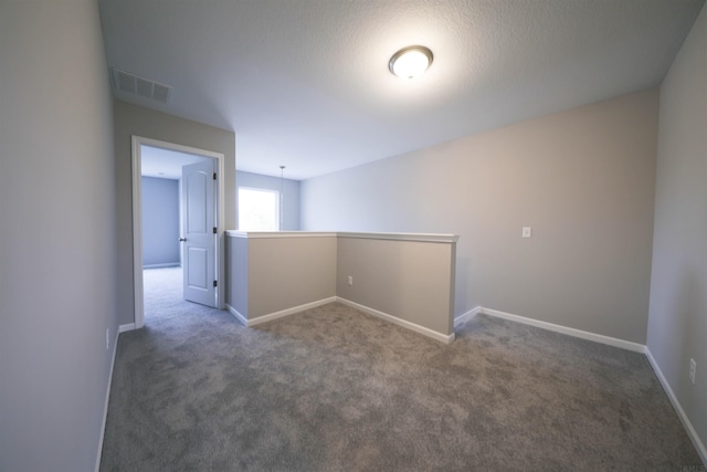 unfurnished room with dark colored carpet