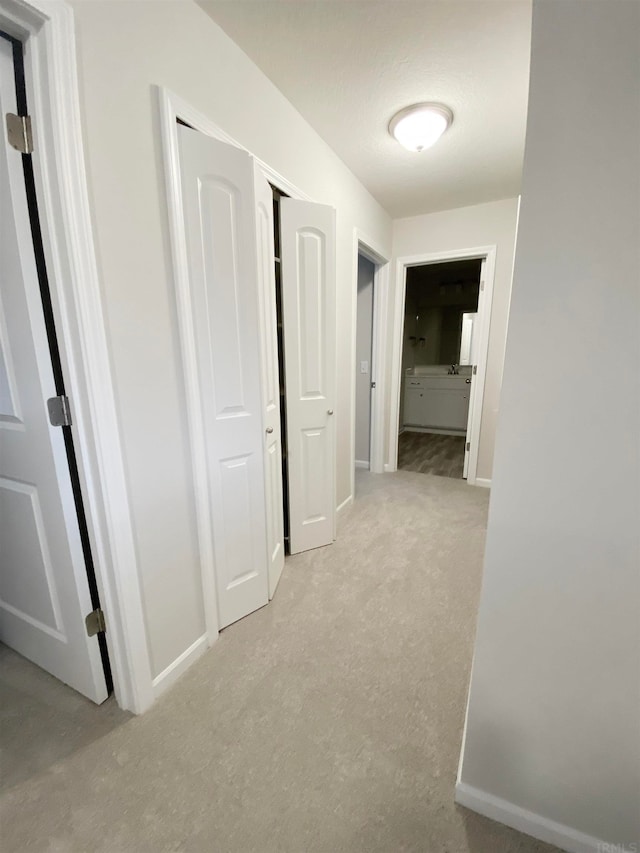 hallway featuring light colored carpet