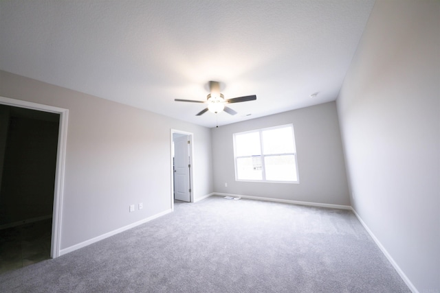 empty room featuring ceiling fan and light colored carpet