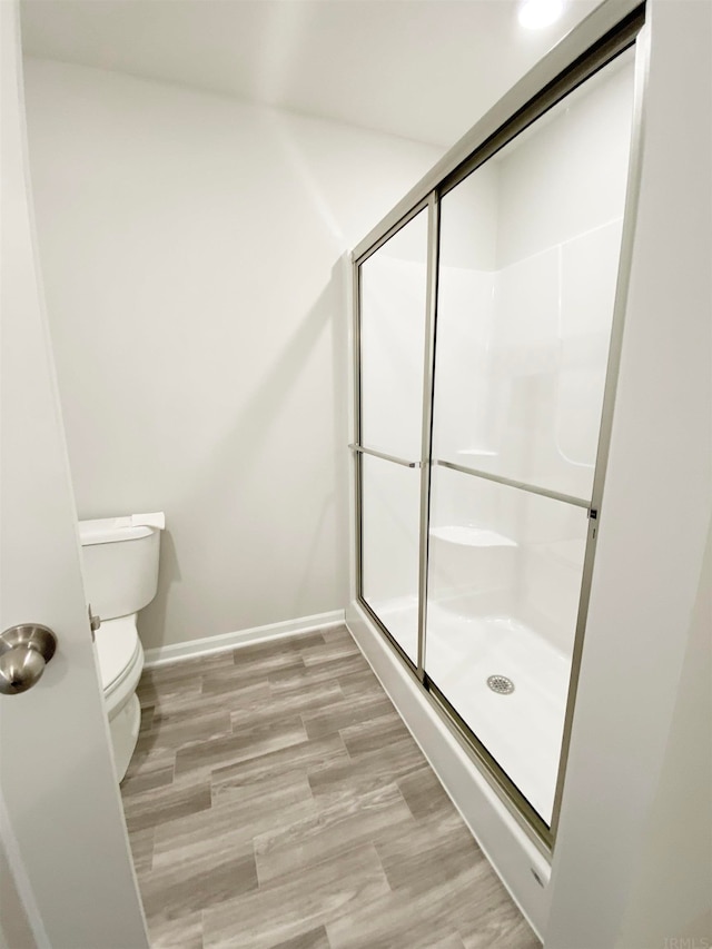 bathroom featuring hardwood / wood-style flooring, toilet, and walk in shower