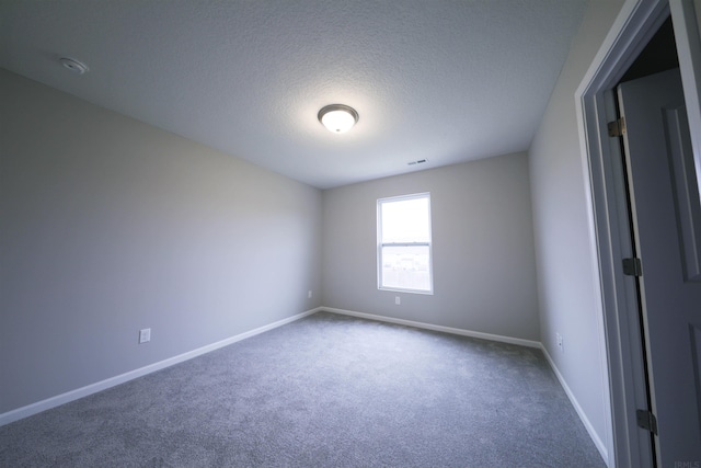 empty room featuring a textured ceiling and carpet floors