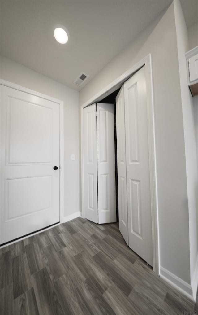 unfurnished bedroom with dark wood-type flooring and a closet