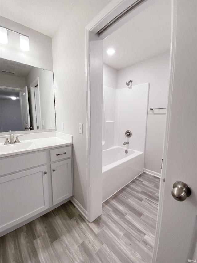 bathroom with bathing tub / shower combination, hardwood / wood-style floors, and vanity