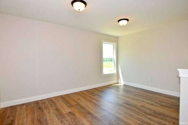 unfurnished room with dark wood-type flooring