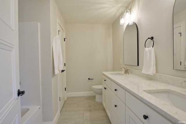 bathroom featuring double sink, tile flooring, toilet, and vanity with extensive cabinet space