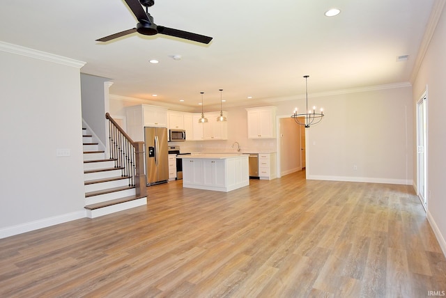 kitchen featuring hanging light fixtures, white cabinets, light hardwood / wood-style flooring, stainless steel appliances, and ceiling fan with notable chandelier