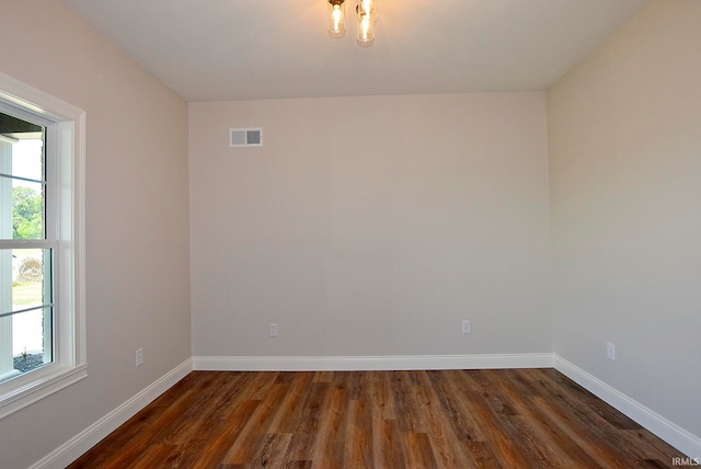 empty room with dark hardwood / wood-style flooring