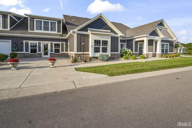 craftsman house featuring a garage and a front lawn