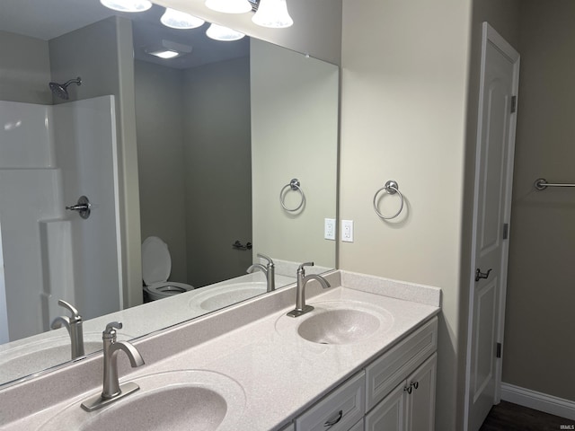 bathroom featuring vanity, a shower, and toilet