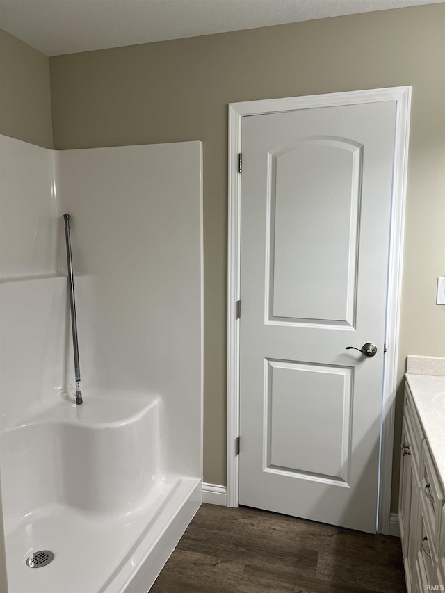 bathroom featuring walk in shower, wood-type flooring, and vanity