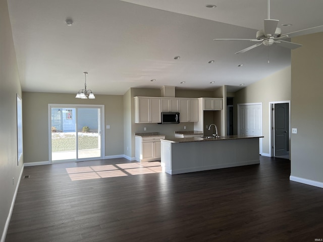 kitchen featuring ceiling fan with notable chandelier, white cabinetry, sink, dark hardwood / wood-style flooring, and a kitchen island with sink