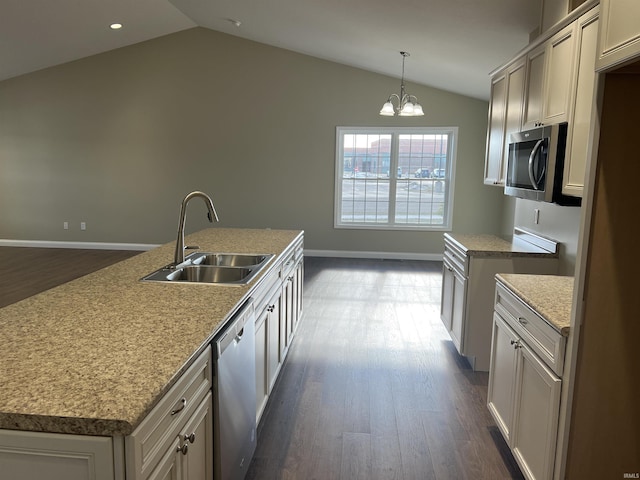 kitchen featuring sink, vaulted ceiling, appliances with stainless steel finishes, and a center island with sink